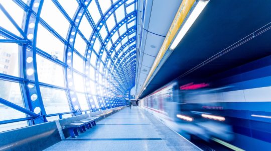 A commuter train passes a platform